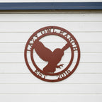 A circular custom metal sign in a smooth Tuscan copper finish, highlighting an owl in flight. The outer border is personalized with the laser-cut text "LAZY OWL RANCH" and "EST. 2016". The piece is installed directly on clean, white horizontal siding positioned beneath a dark blue trim piece.