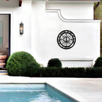 Personalized nautical compass metal wall decor displayed beside modern outdoor pool and white exterior wall