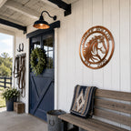 Copper custom horse metal sign mounted on white barn wall near rustic bench