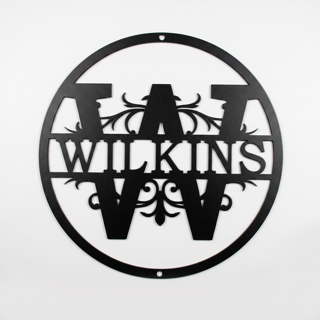 Flat view of a black circular personalized metal sign featuring a prominent letter W split monogram with elegant filigree accents and the custom surname Wilkins over a solid white background.