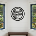 A circular black metal sign reading "Jane's Pond Est. 2022" with a detailed koi fish and lotus flowers, mounted indoors on a white shiplap wall between two large windows.
