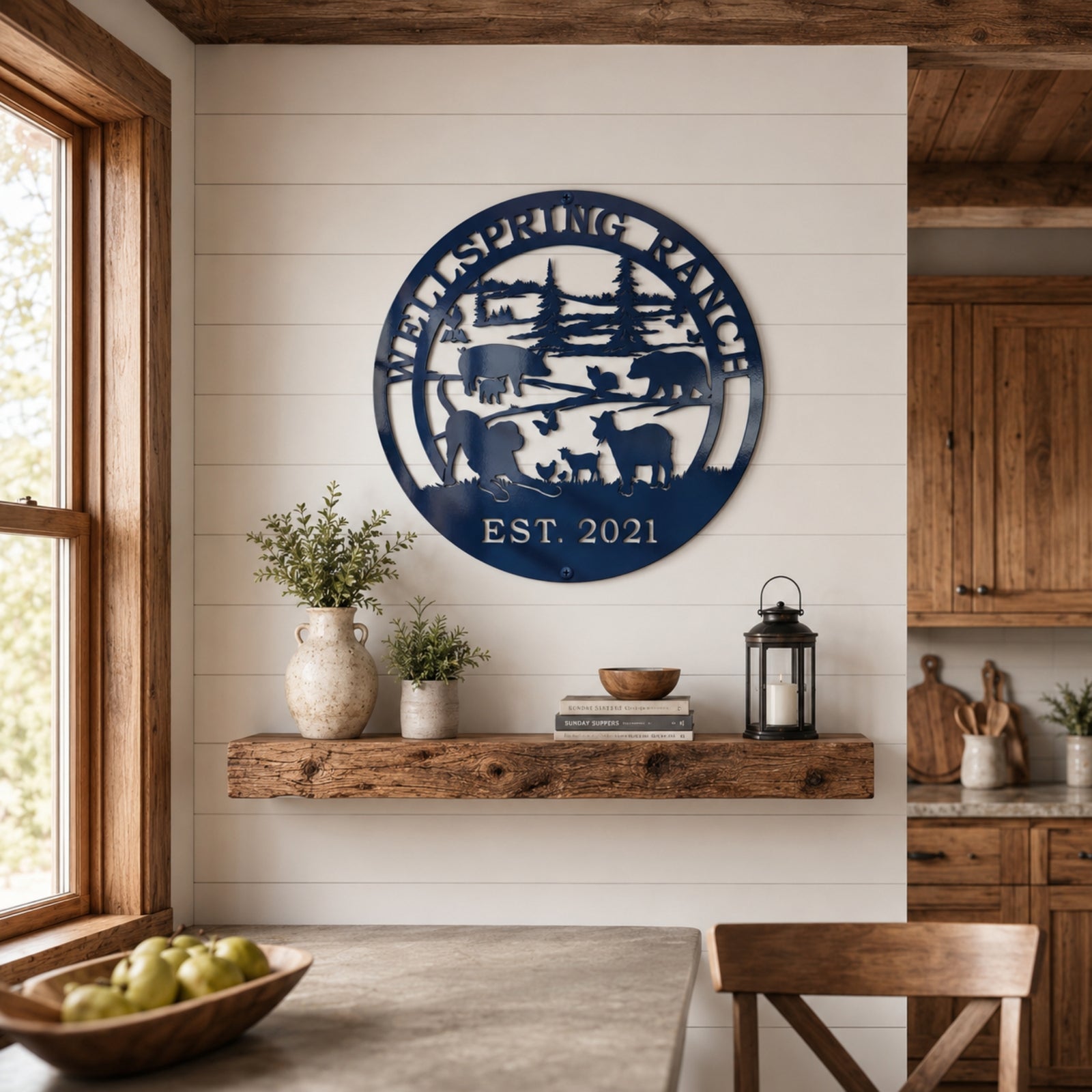Round navy blue ranch metal wall décor with custom ranch name and EST 2021 displayed above wooden floating shelf in farmhouse kitchen