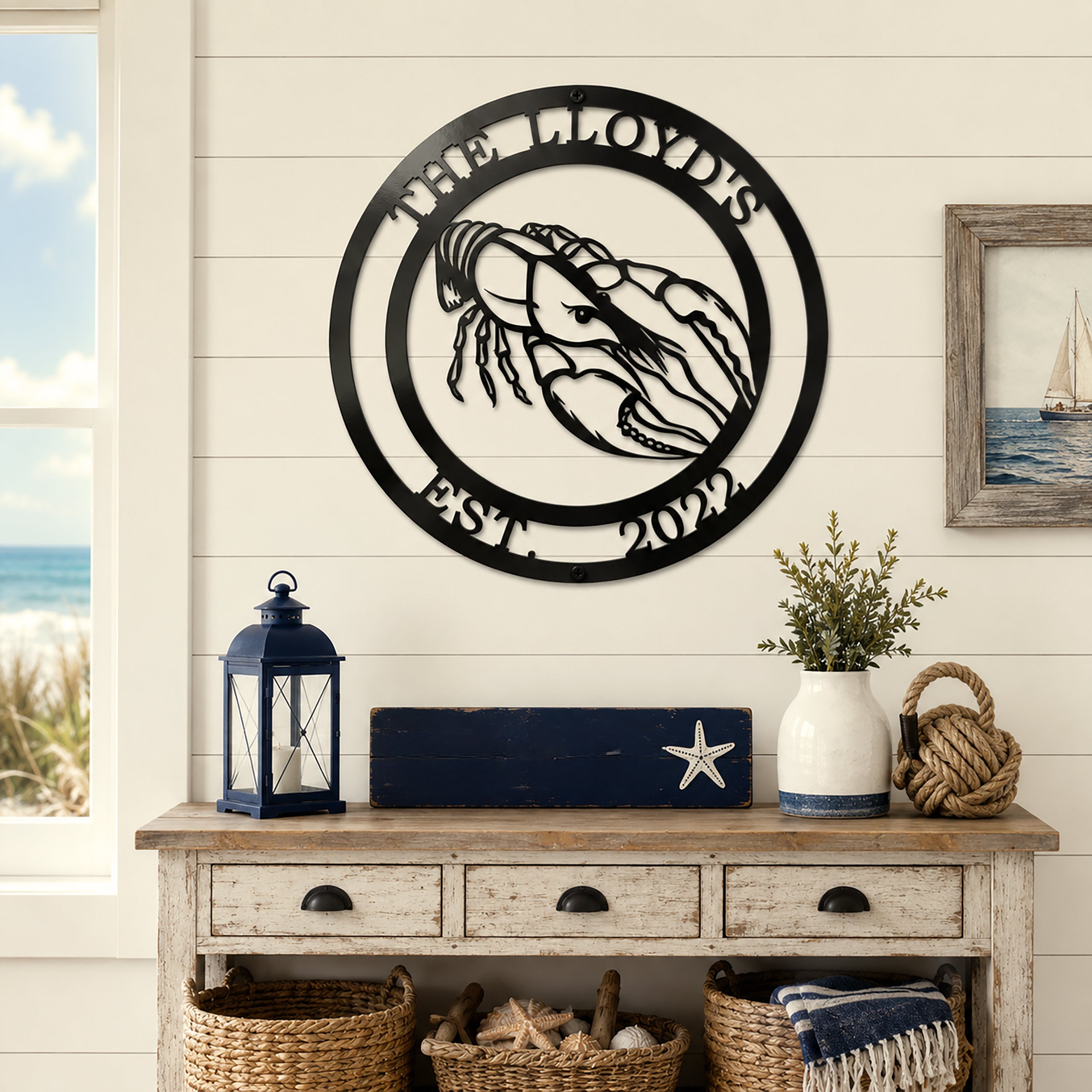 Black lobster metal wall sign with The Lloyds and Est 2022 displayed above coastal console table and nautical decor