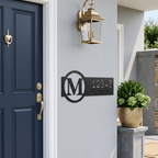 Black custom monogram house number sign displayed near front door with wall lantern
