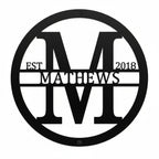 Custom black metal monogram sign featuring the letter M, family name Matthews, and established year 2018 on a white background.