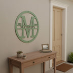 Custom Sage Green metal monogram sign featuring the letter M, family name Matthews, and established year mounted above a console table.