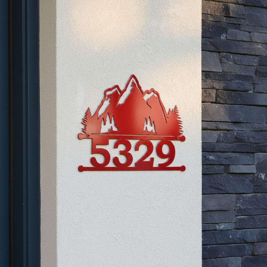 Red mountain metal address sign with 5329 displayed on a white stucco wall near dark stone siding