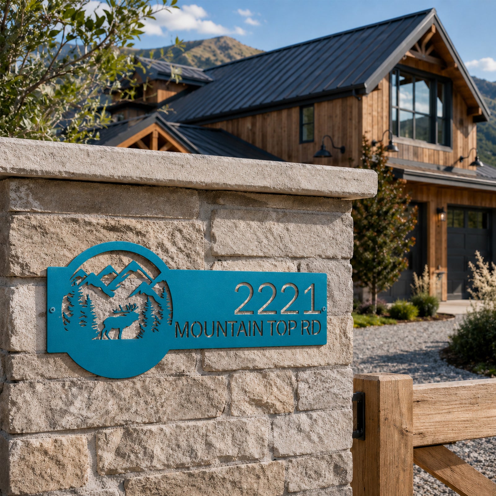 Turquoise mountain elk metal address sign mounted on stone entry pillar outside rustic mountain style home