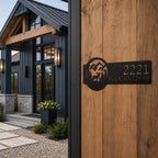 Black custom mountain lodge address sign with elk and pine tree design mounted beside modern cabin entrance