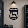 Personalized K9 Hondo badge metal wall art displayed in police K9 unit room with gear storage