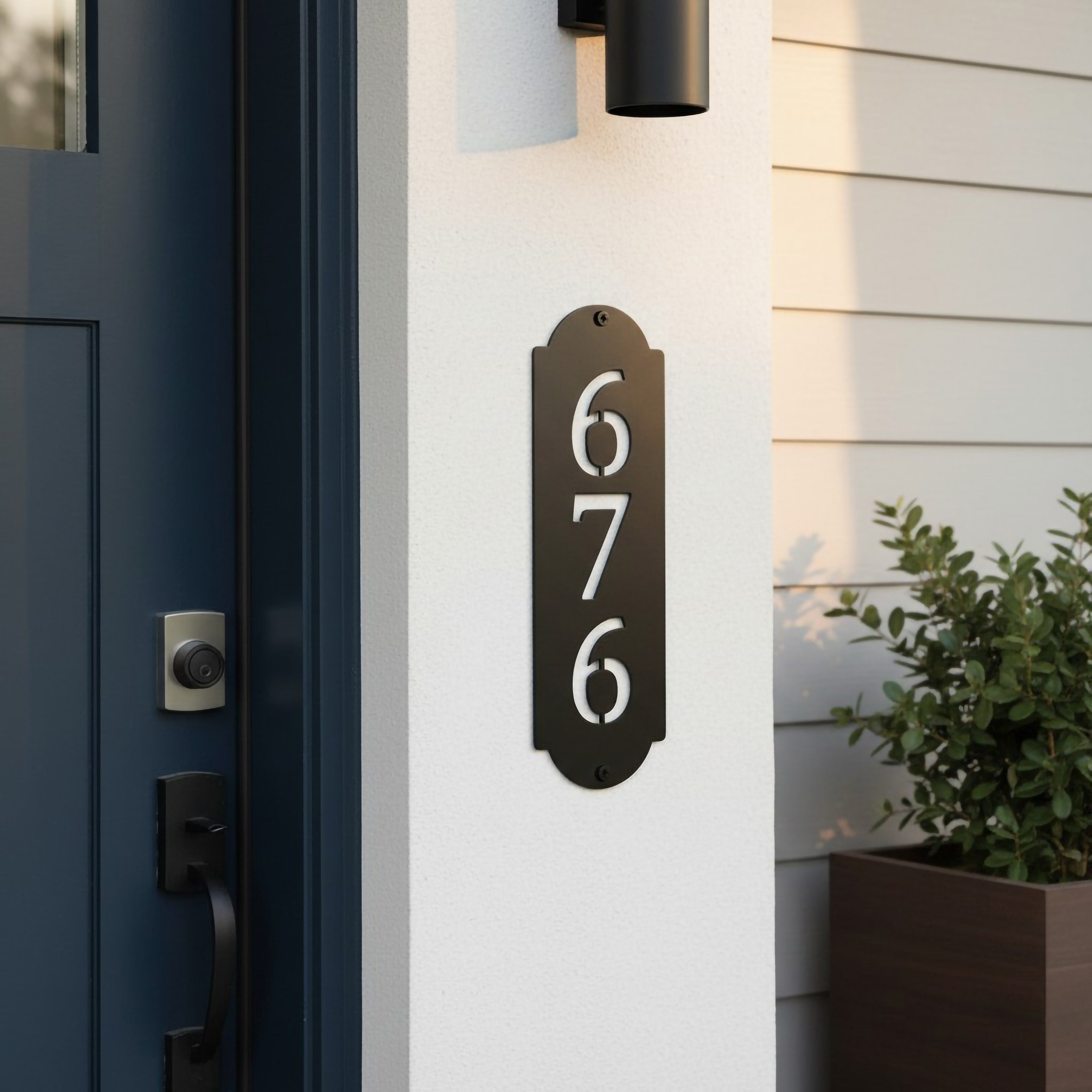 Satin black vertical address number plaque with cutout numbers displayed beside a modern front door