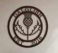 Close-up product shot of a dark espresso brown circular metal wall sign featuring a Scottish thistle flower design with custom name Dalglish and Est 2016.