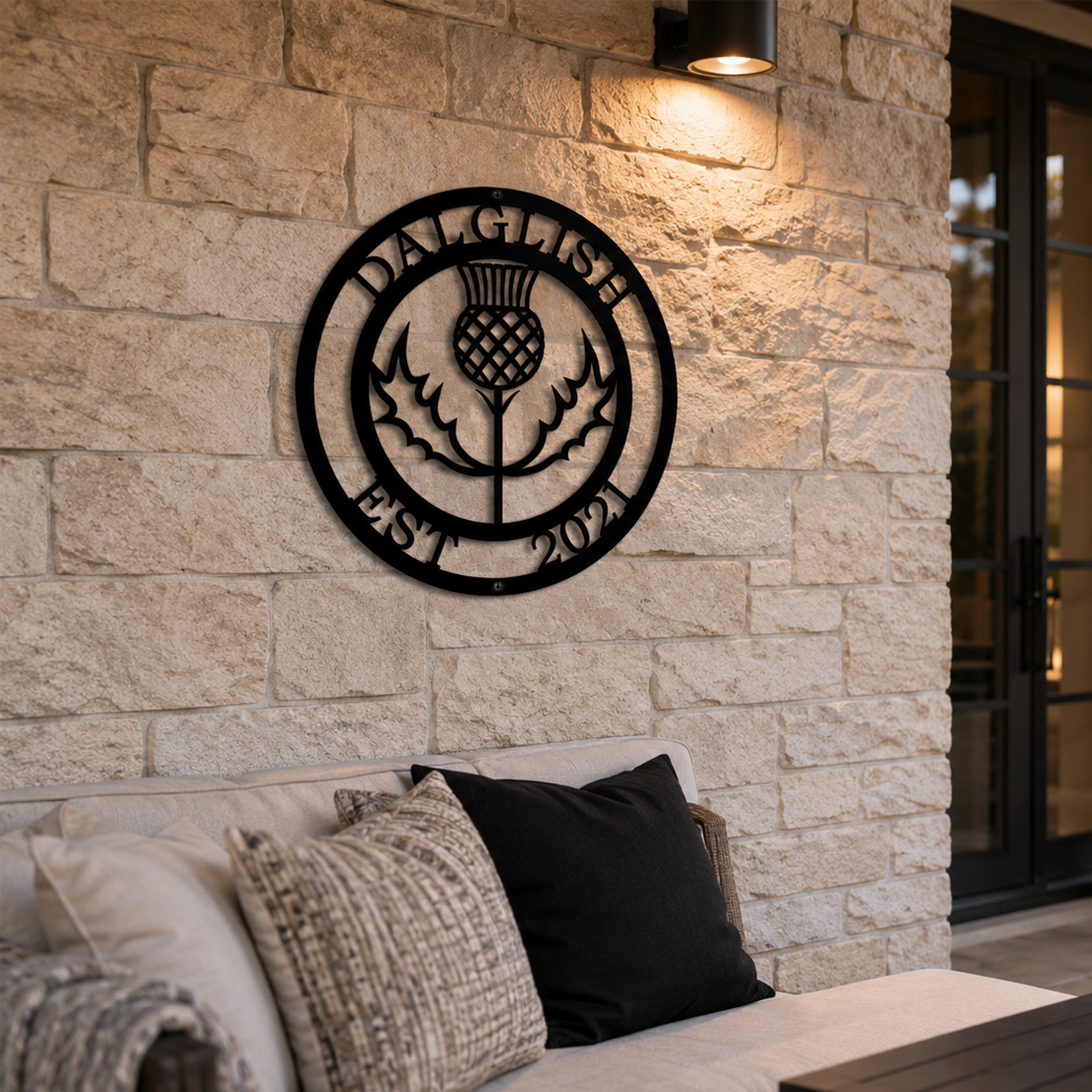 Custom Scottish thistle metal sign — personalized clan crest outdoor wall art mounted on a natural stone wall in a covered patio setting.