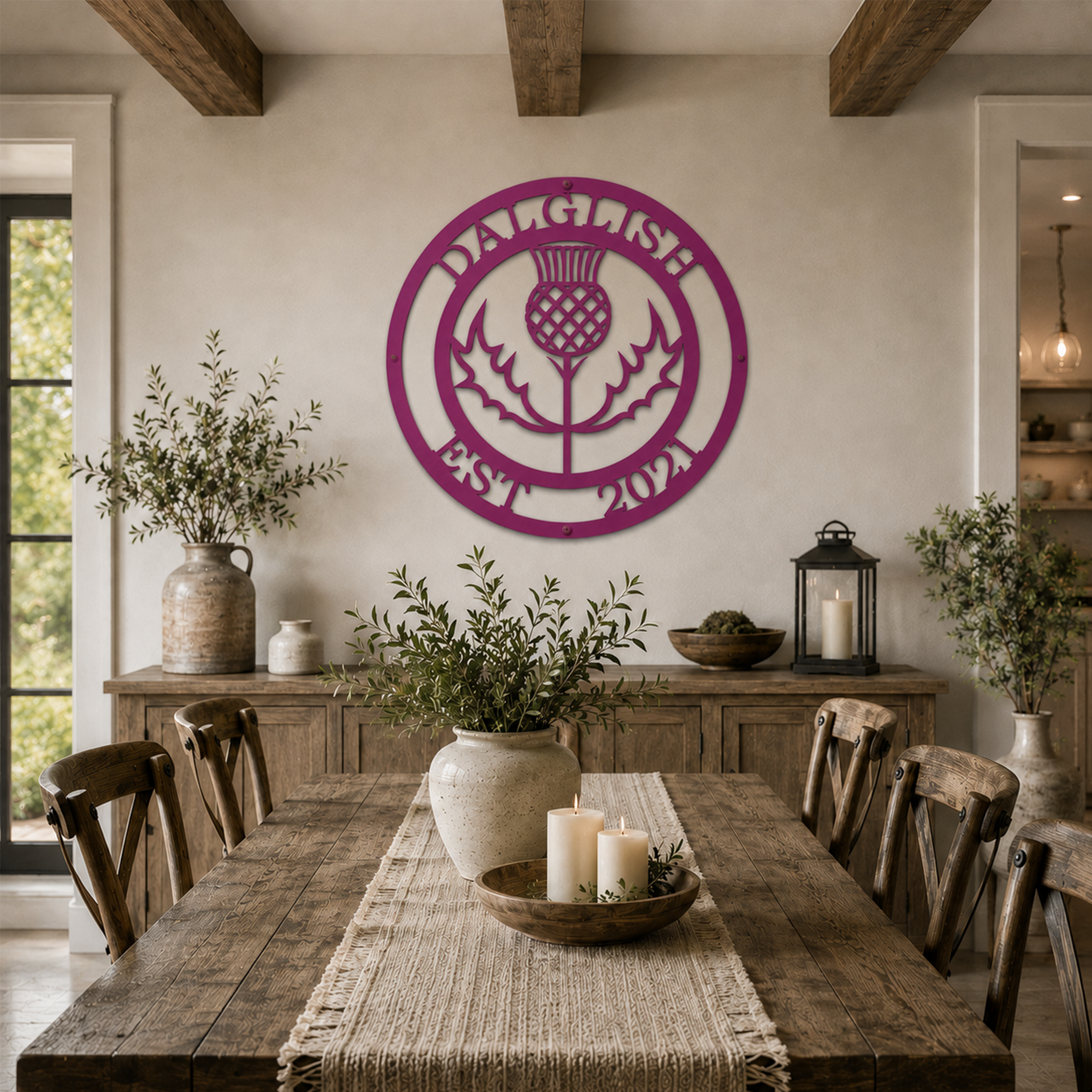 Custom Scottish thistle metal sign — personalized clan name wall art in magenta powder-coated steel displayed above a rustic farmhouse dining room table.