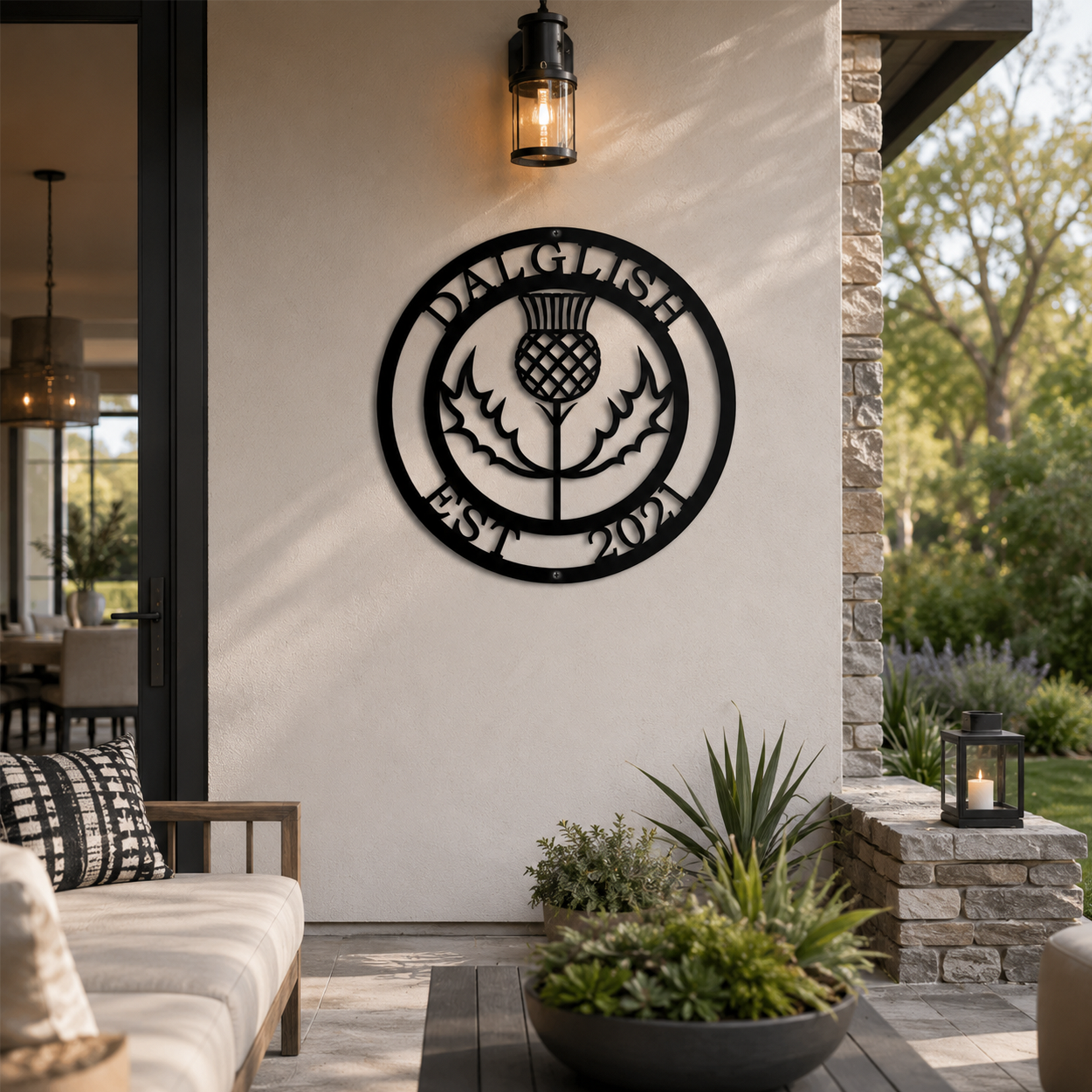Custom Scottish thistle metal sign — personalized family name outdoor decor in black powder-coated steel mounted on a covered patio wall.