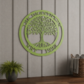 A refreshing lime green powder-coated circular metal sign featuring the text "THE GRANTHAMS EST. 1992" around a decorative tree silhouette. It is mounted indoors on a vertical slate-gray shiplap accent wall above a wooden floor, next to a potted green fern and a woven towel basket.