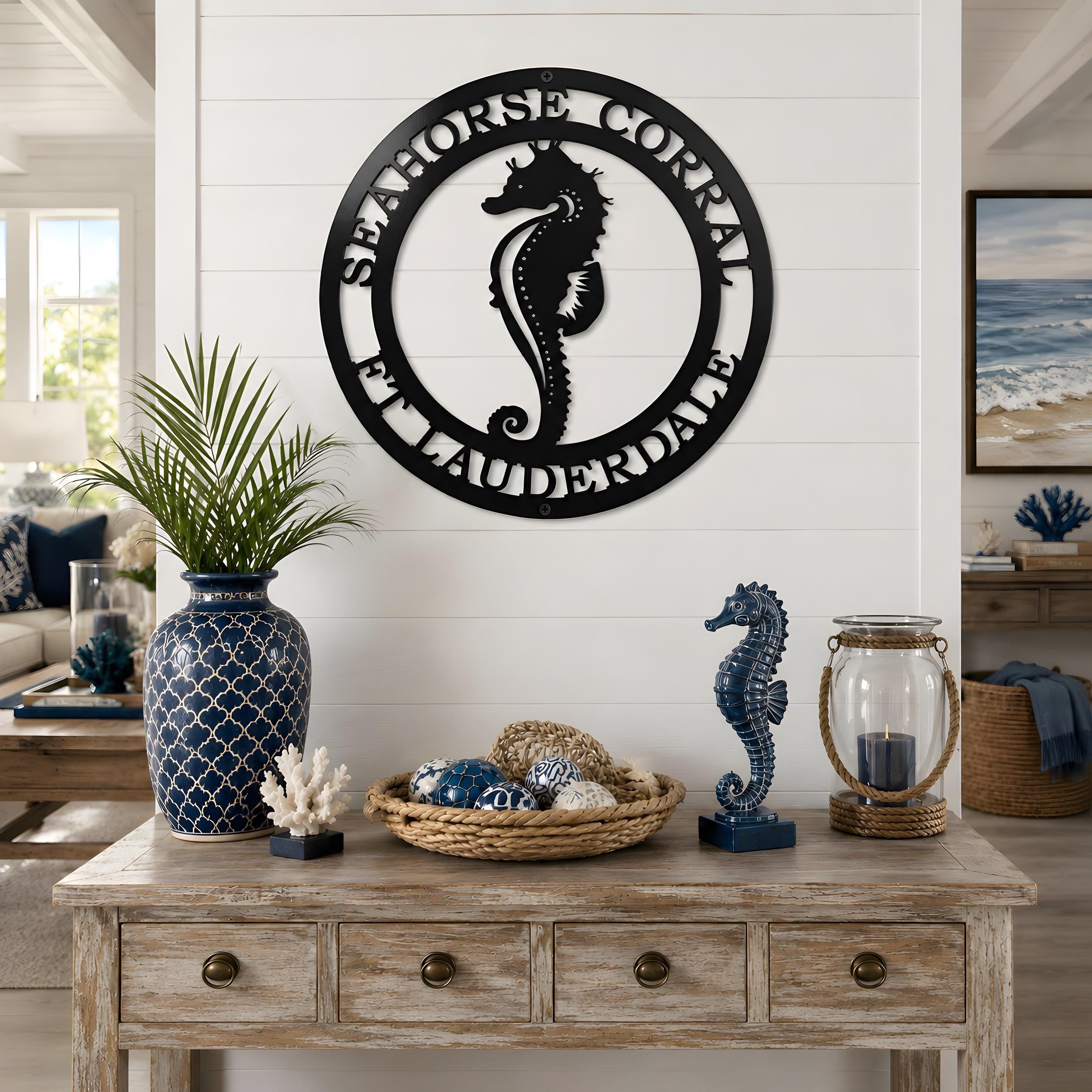 Black seahorse coastal metal wall sign displayed above rustic console table with nautical beach decor accessories