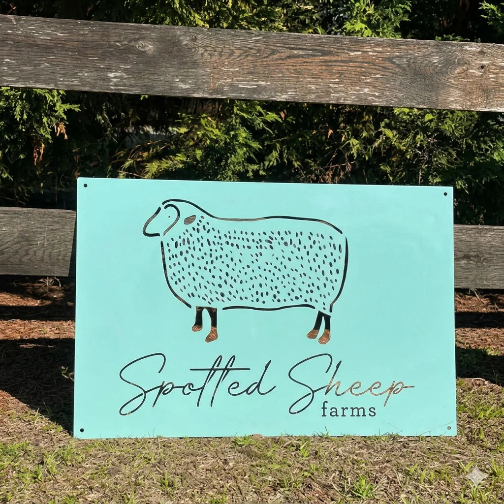 Personalized spotted sheep farm metal sign with sheep illustration and custom farm branding displayed outdoors by wooden fence