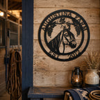 Black horse farm metal wall sign displayed on wooden stable exterior with horse stalls and rustic barn setting
