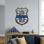 Personalized thin blue line metal monogram sign displayed above sofa with folded American flag and modern living room decor