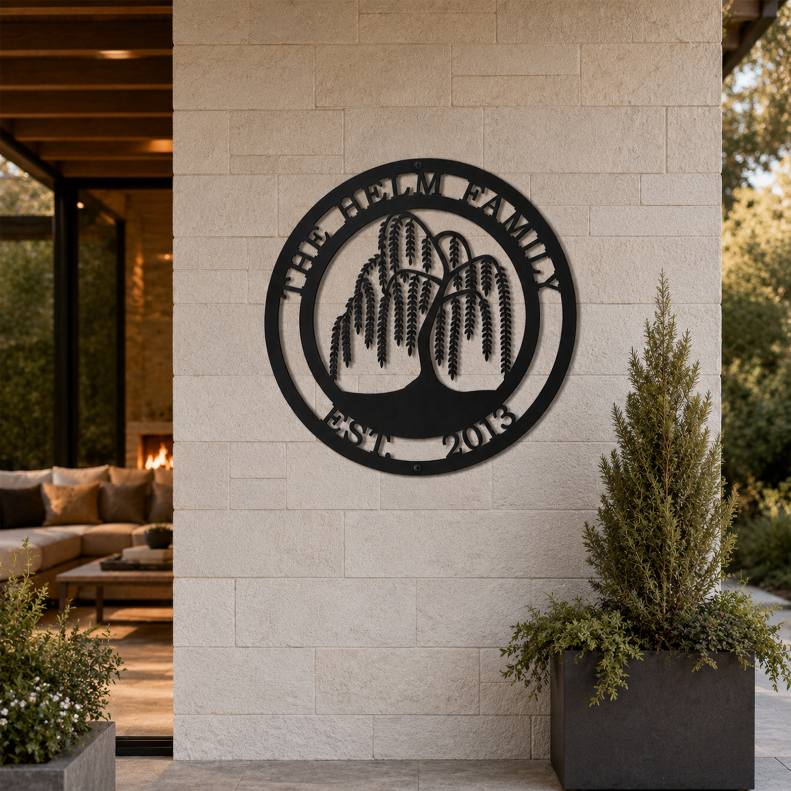 Custom weeping willow tree metal sign — personalized family name wall decor in black powder-coated steel displayed on a covered outdoor patio wall.