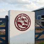 Deep red pig resort metal sign with barn and pig silhouettes mounted on a white farm gate post