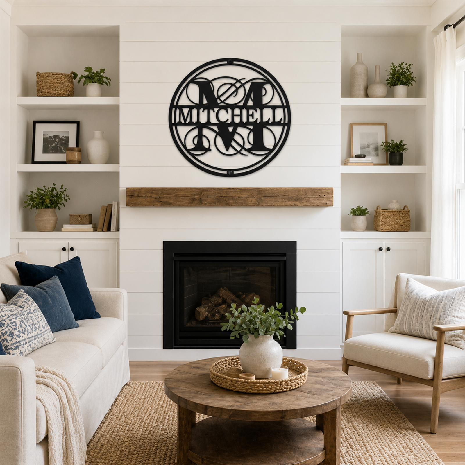 Black circular monogram family name sign with Mitchell lettering displayed above a living room fireplace in a bright modern home