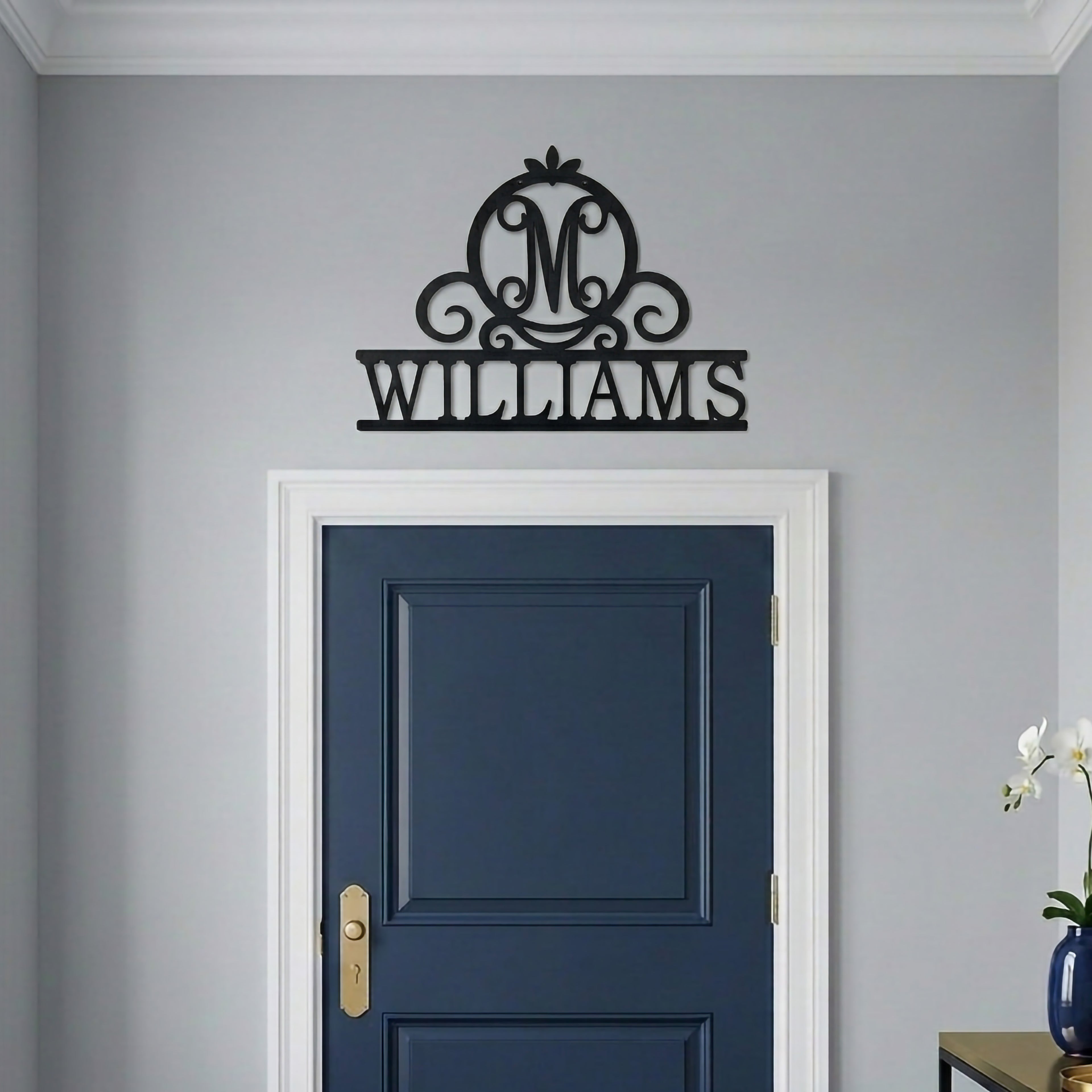 Black Williams monogram metal wall sign mounted above a navy blue interior door with minimalist modern home decor