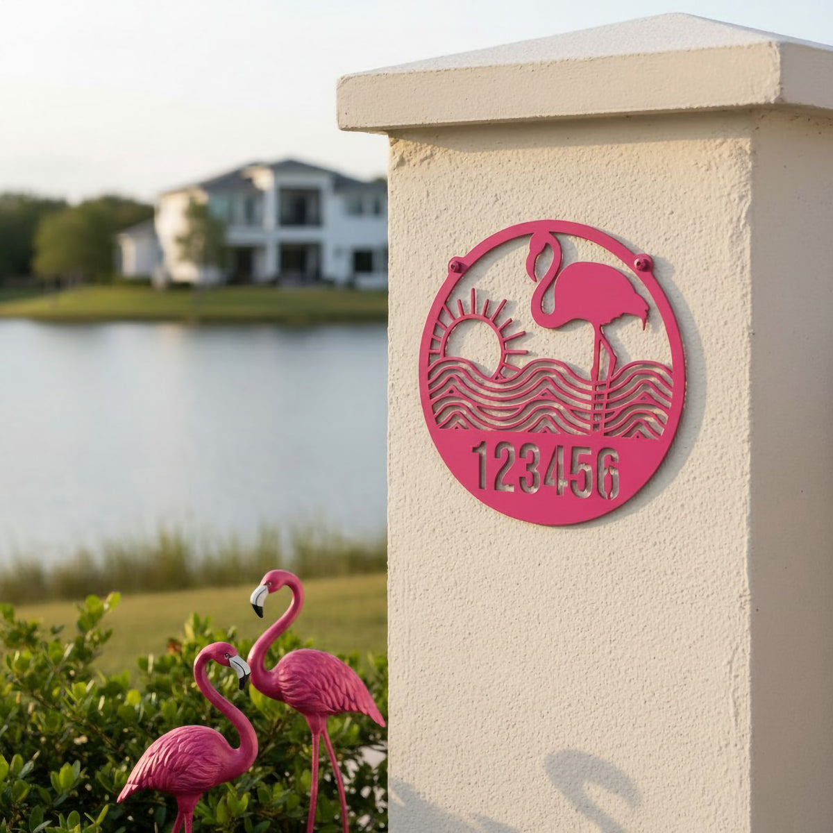 Sassy pink flamingo metal address sign with sun and waves mounted beside lake view