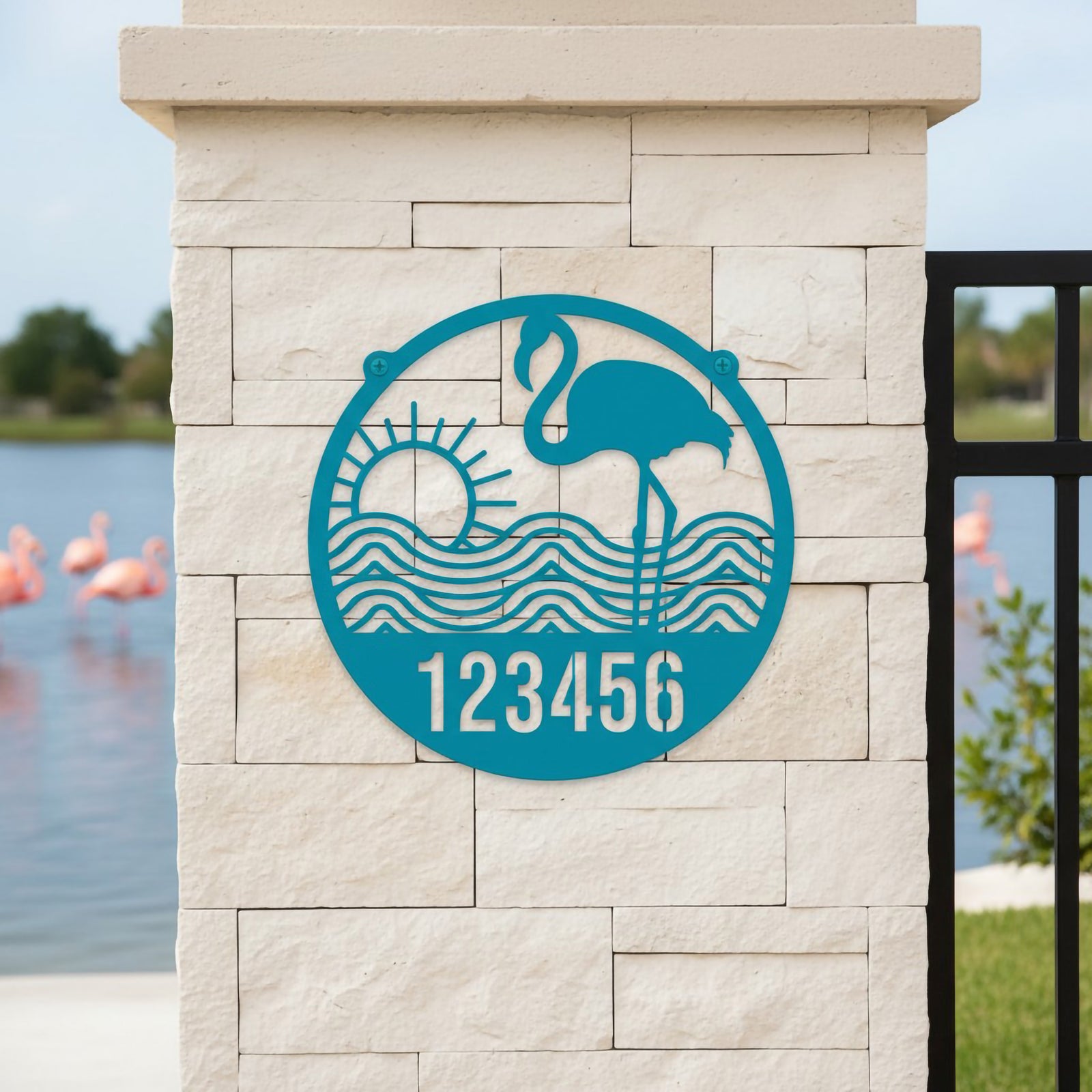 Turquoise flamingo address plaque with sun and wave design mounted by lakeside entrance