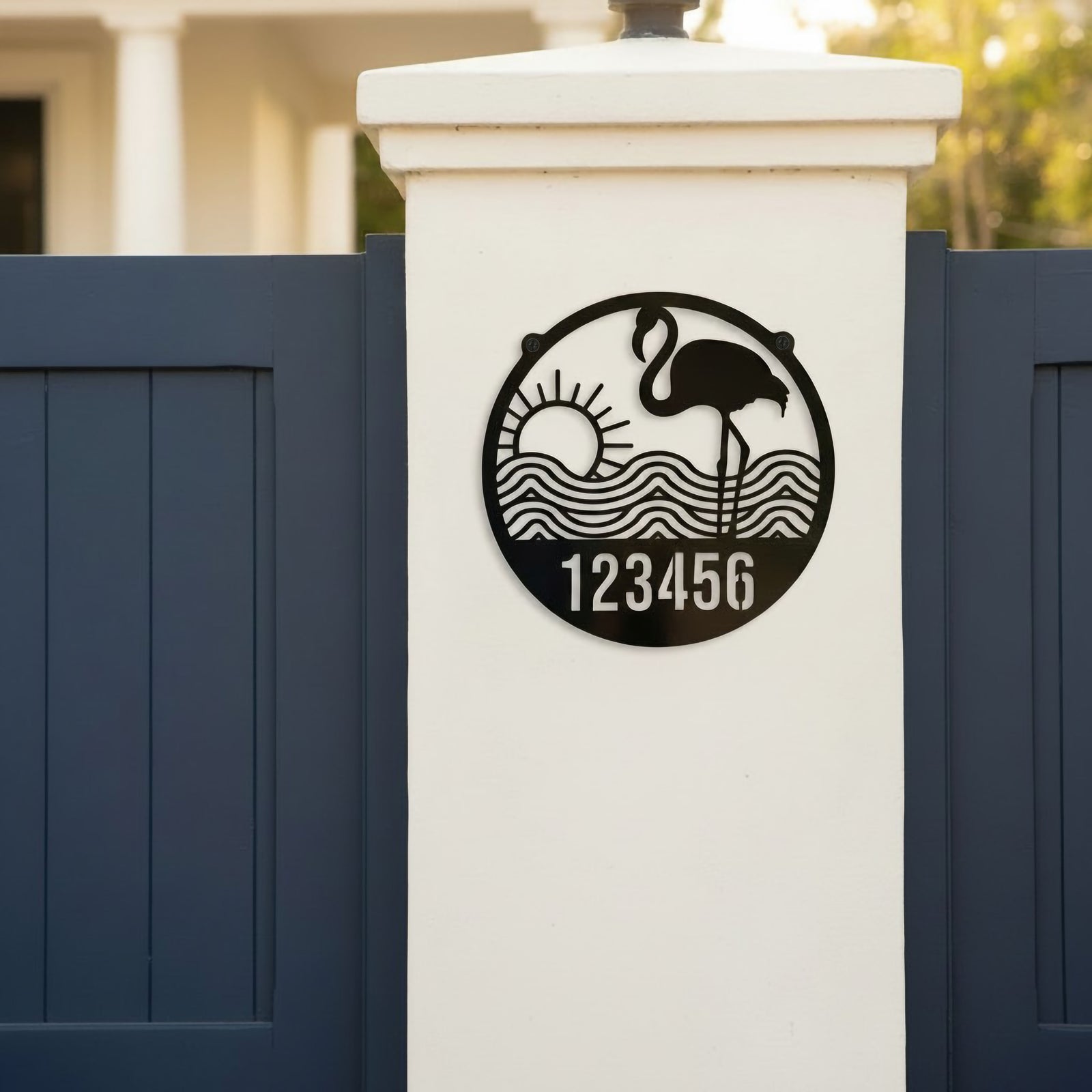 Gloss black flamingo address sign with sun waves and number 123456 on white gate pillar