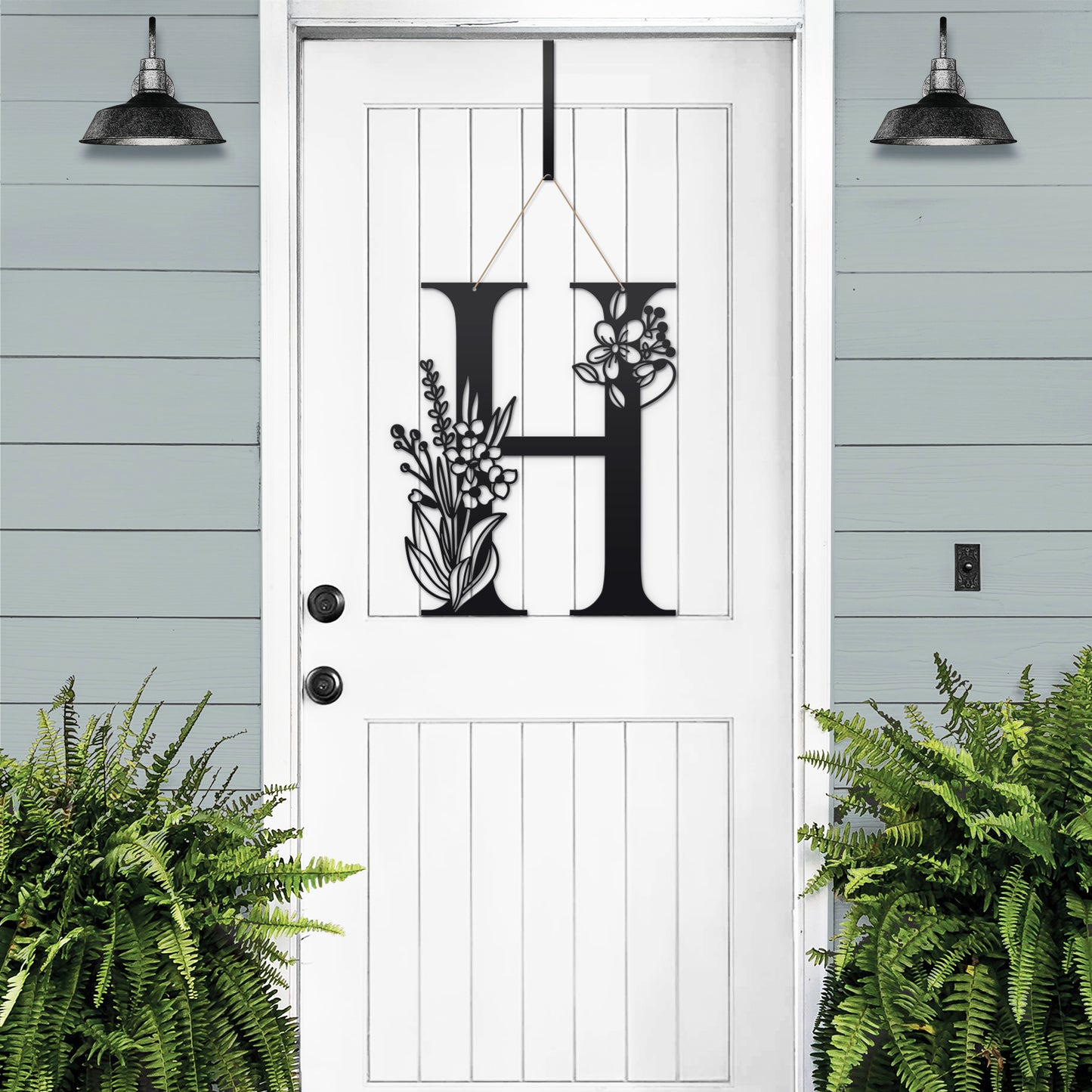 Metal Floral Monogram Door Wreath showcasing a personalized black letter with floral accents on a white door, ideal for adding elegance and individuality to any entryway or outdoor space.