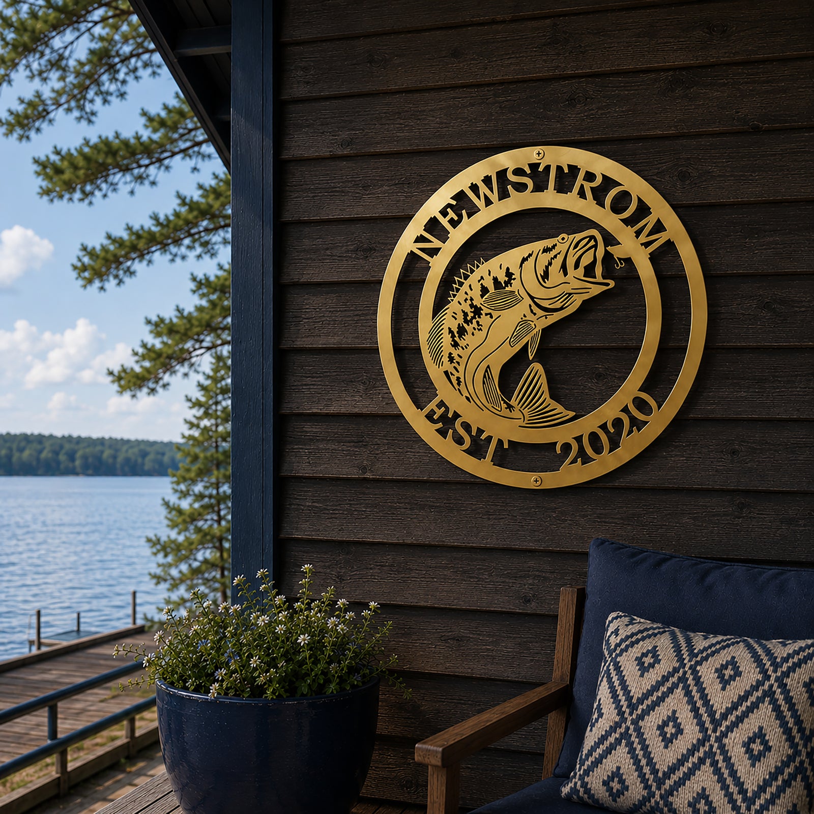 Gold bass fish metal wall sign with Newstrom and Est 2020 mounted on dark wood lake cabin exterior