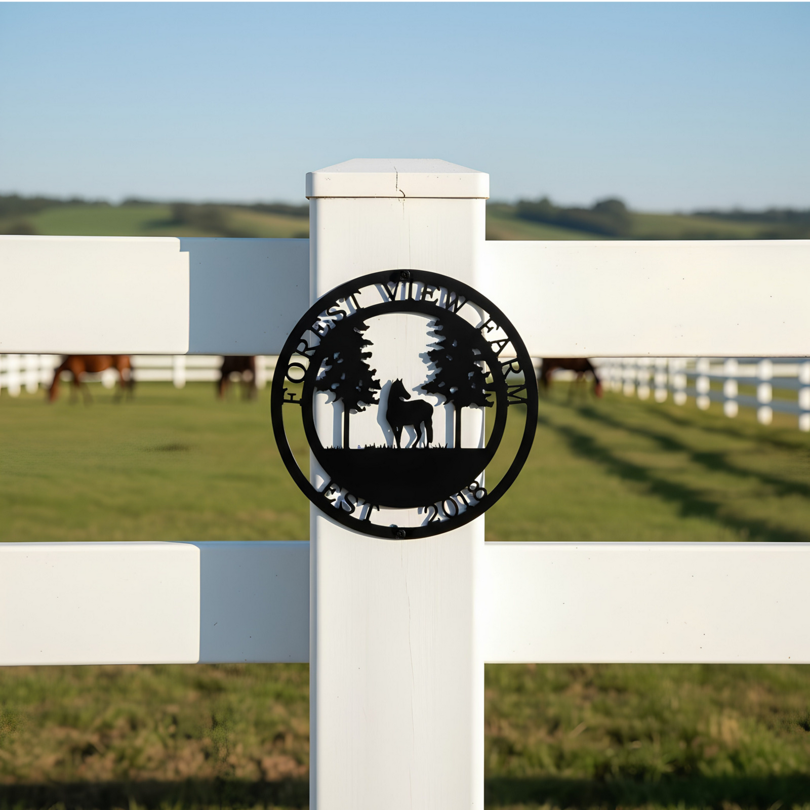 Gold Forest View Farm metal sign with horse and pine tree design mounted on a stone gate post near white farm fencing