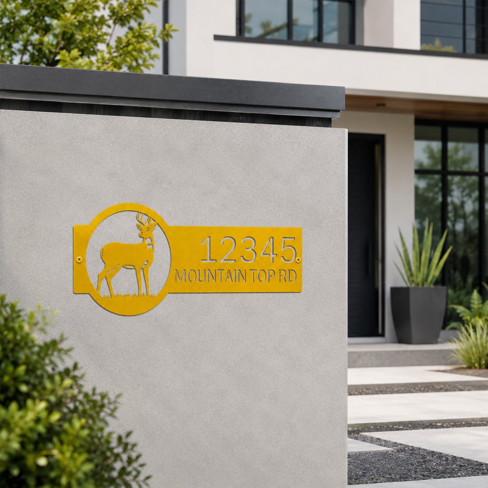 Golden yellow deer metal address plaque mounted on concrete wall with custom house number and mountain top road text modern outdoor entry sign