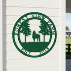 Green custom Forest View Farm metal sign with horse and pine tree design displayed on white exterior siding near farm fencing