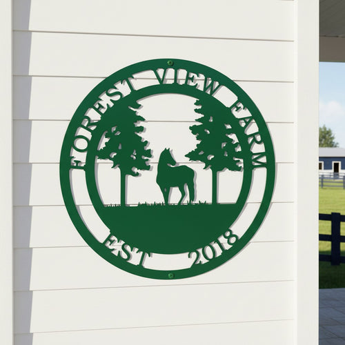 Green custom Forest View Farm metal sign with horse and pine tree design displayed on white exterior siding near farm fencing