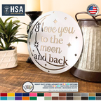 White round metal sign with moon stars and I love you to the moon and back quote displayed on rustic wood table for romantic home decor gift