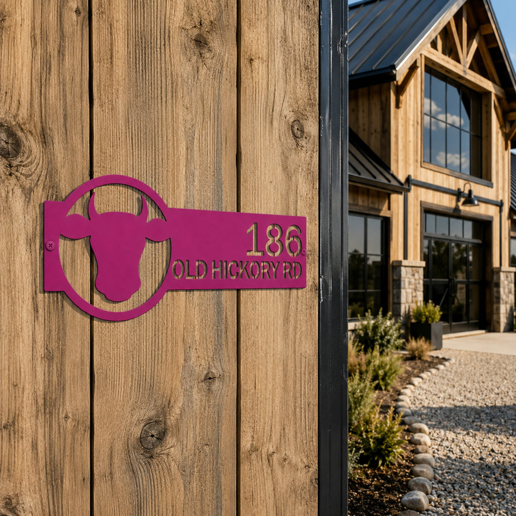 Magenta custom bull head metal address sign mounted on wooden exterior wall beside modern farmhouse entrance