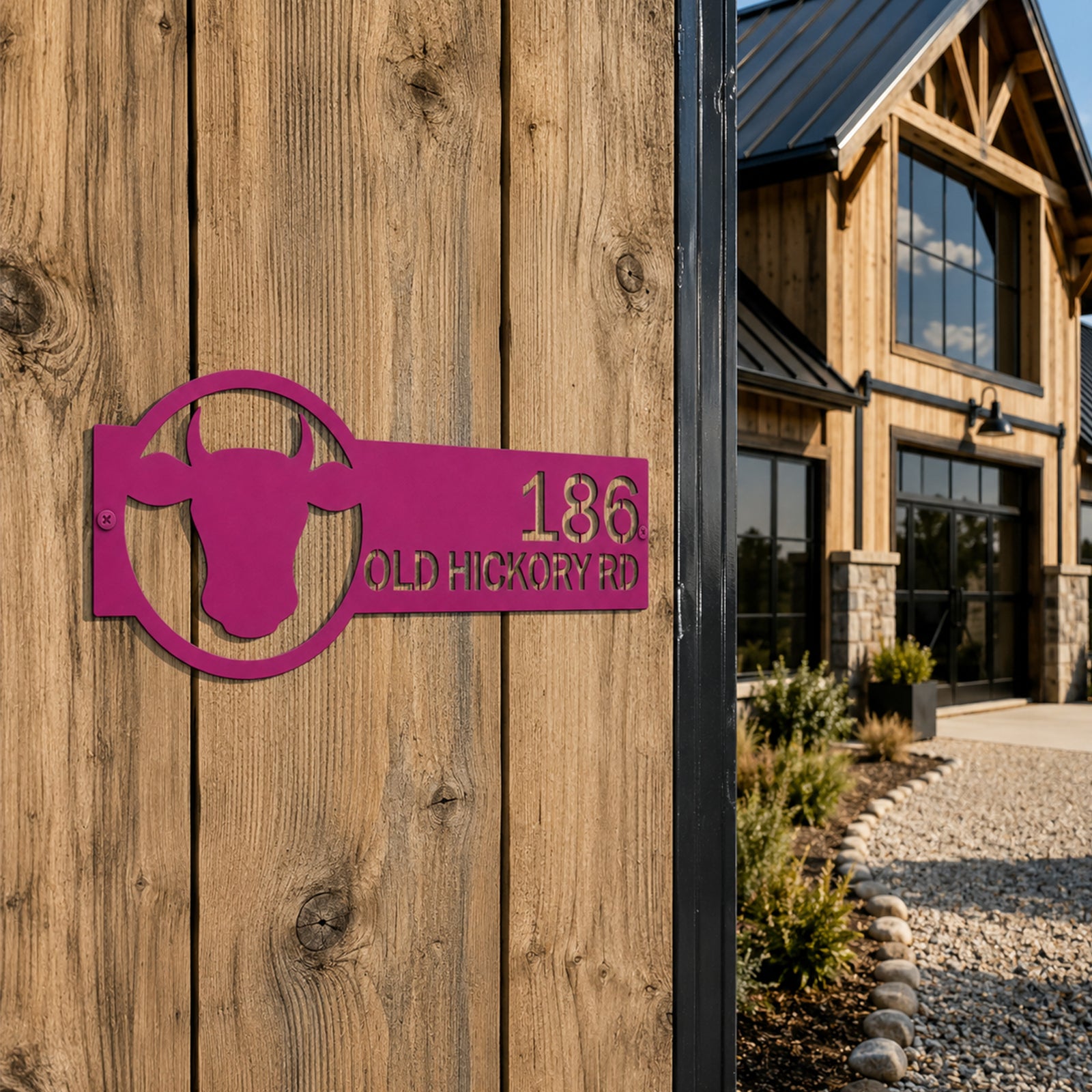 Magenta custom bull head metal address sign mounted on wooden exterior wall beside modern farmhouse entrance