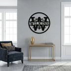 Black circular metal family monogram sign mounted on a minimalist living room wall with modern furniture accents