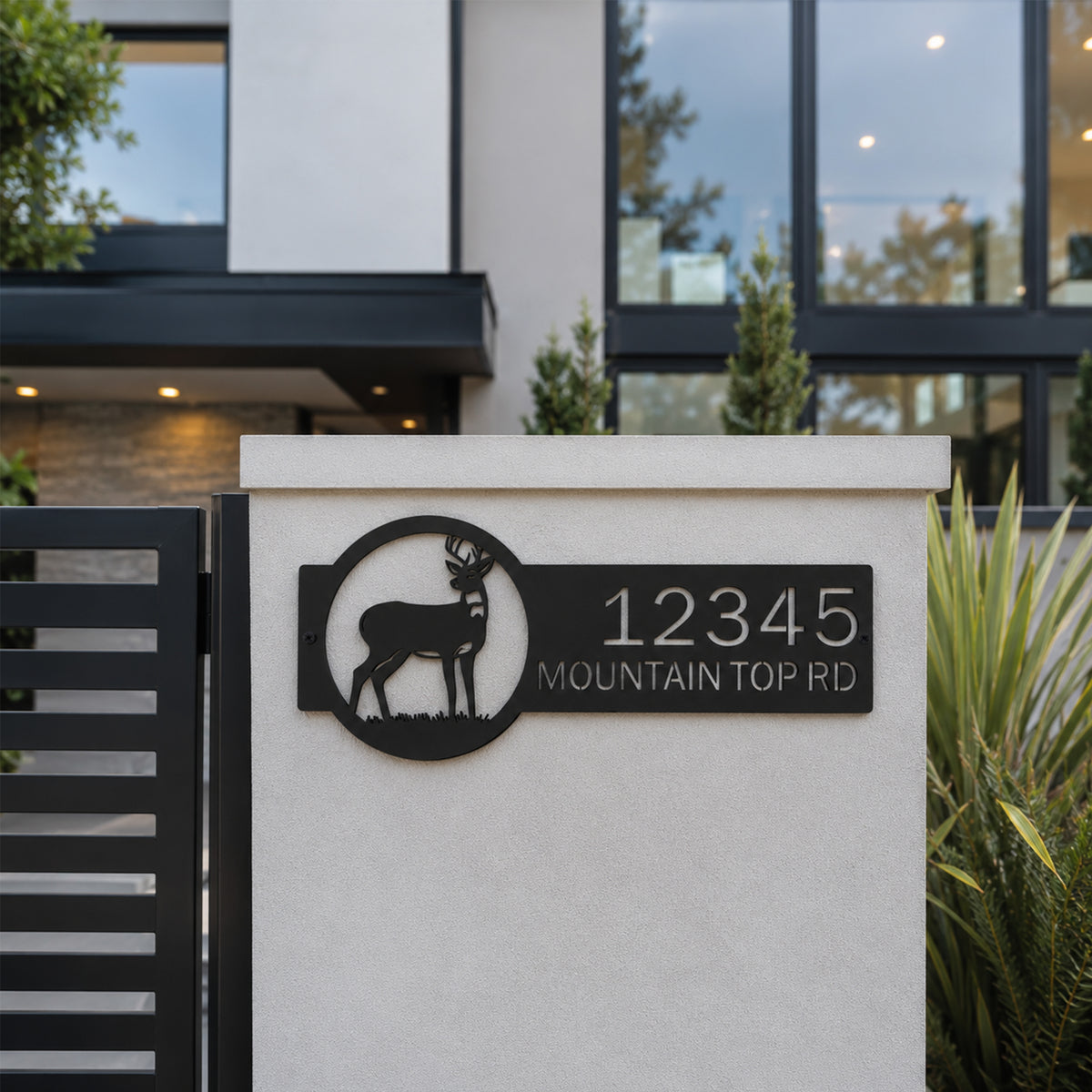Black deer metal address sign mounted on front gate wall with personalized house number and modern farmhouse exterior background