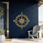 Modern Gold Personalized Compass Rose Metal House Plaque mounted on a dark navy blue exterior wall by the pool.