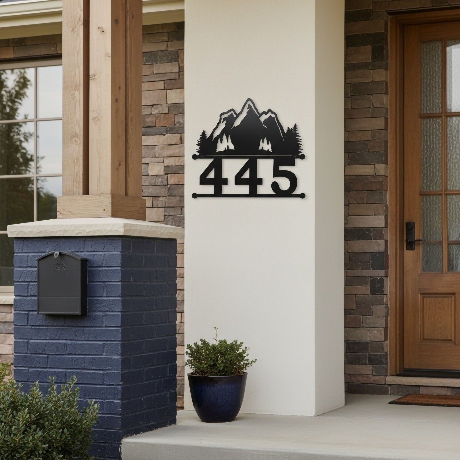 Black mountain house number sign with 445 mounted beside a front porch and stone entryway