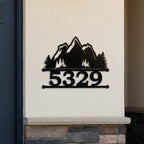 Black mountain scene metal house number sign with 5329 mounted on a white exterior wall