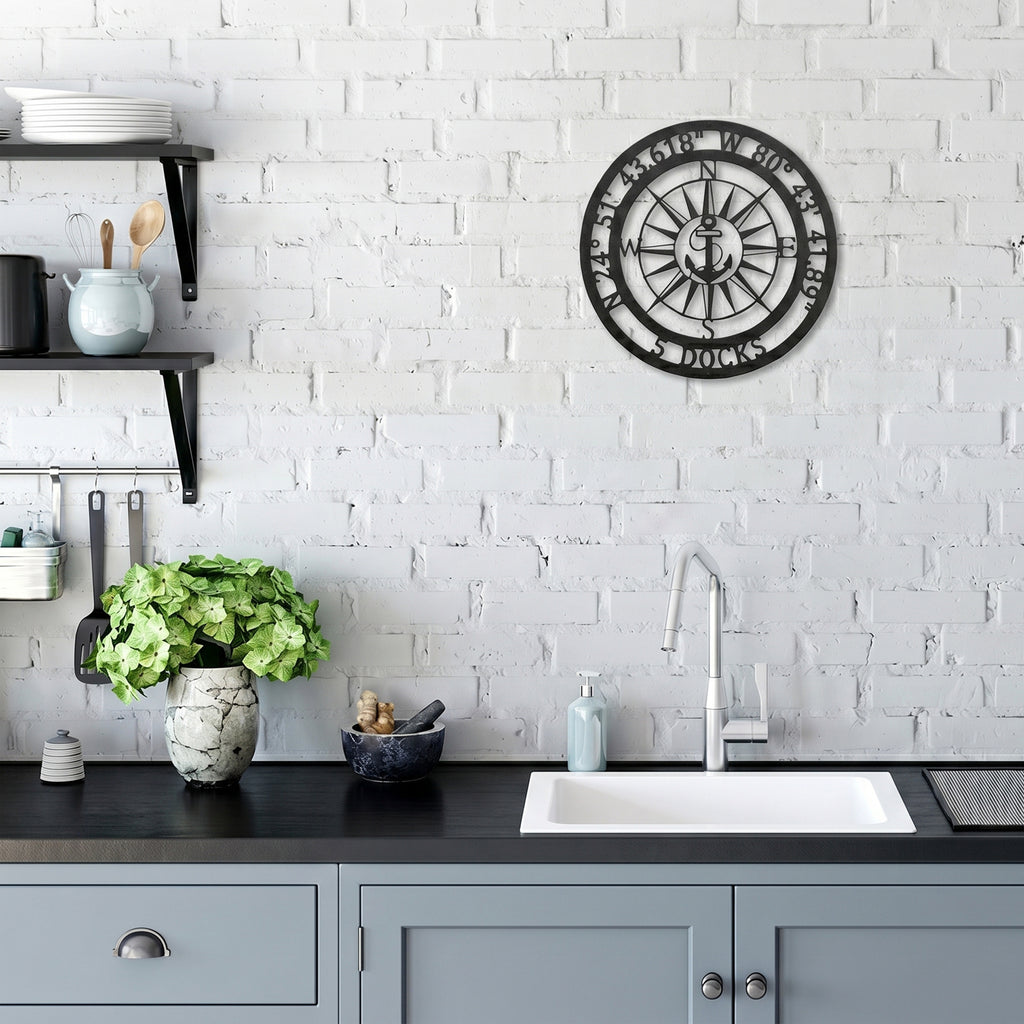 Custom compass metal wall art with anchor design displayed on white brick kitchen wall above sink area
