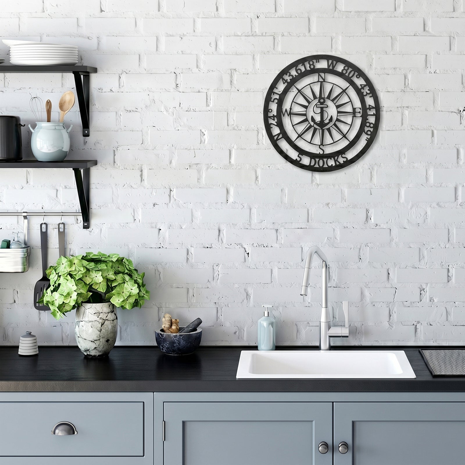 Custom compass metal wall art with anchor design displayed on white brick kitchen wall above sink area
