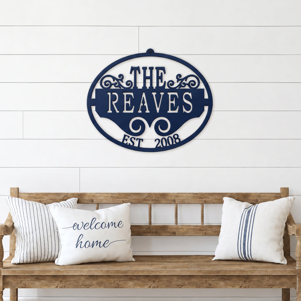 Navy blue personalized family name metal wall sign with established date displayed above rustic wooden bench décor