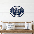 Navy blue personalized family name metal wall sign with established date displayed above rustic wooden bench décor