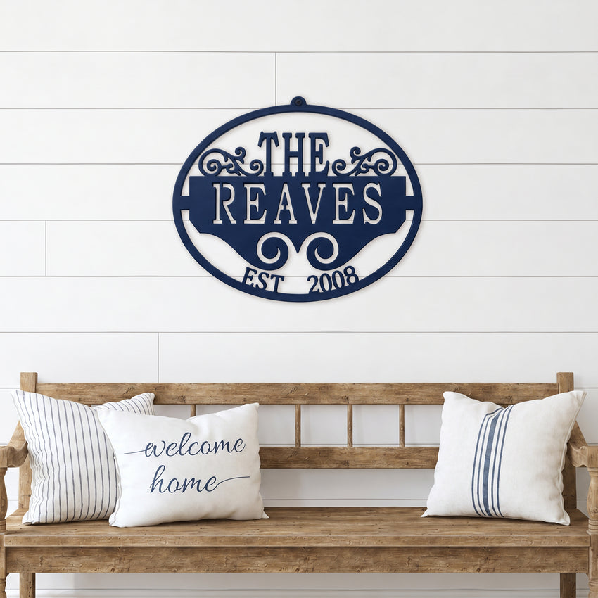 Navy blue personalized family name metal wall sign with established date displayed above rustic wooden bench décor